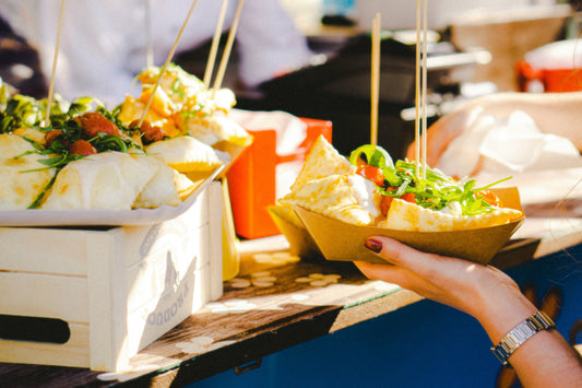person hold paper plate with food at a picknick