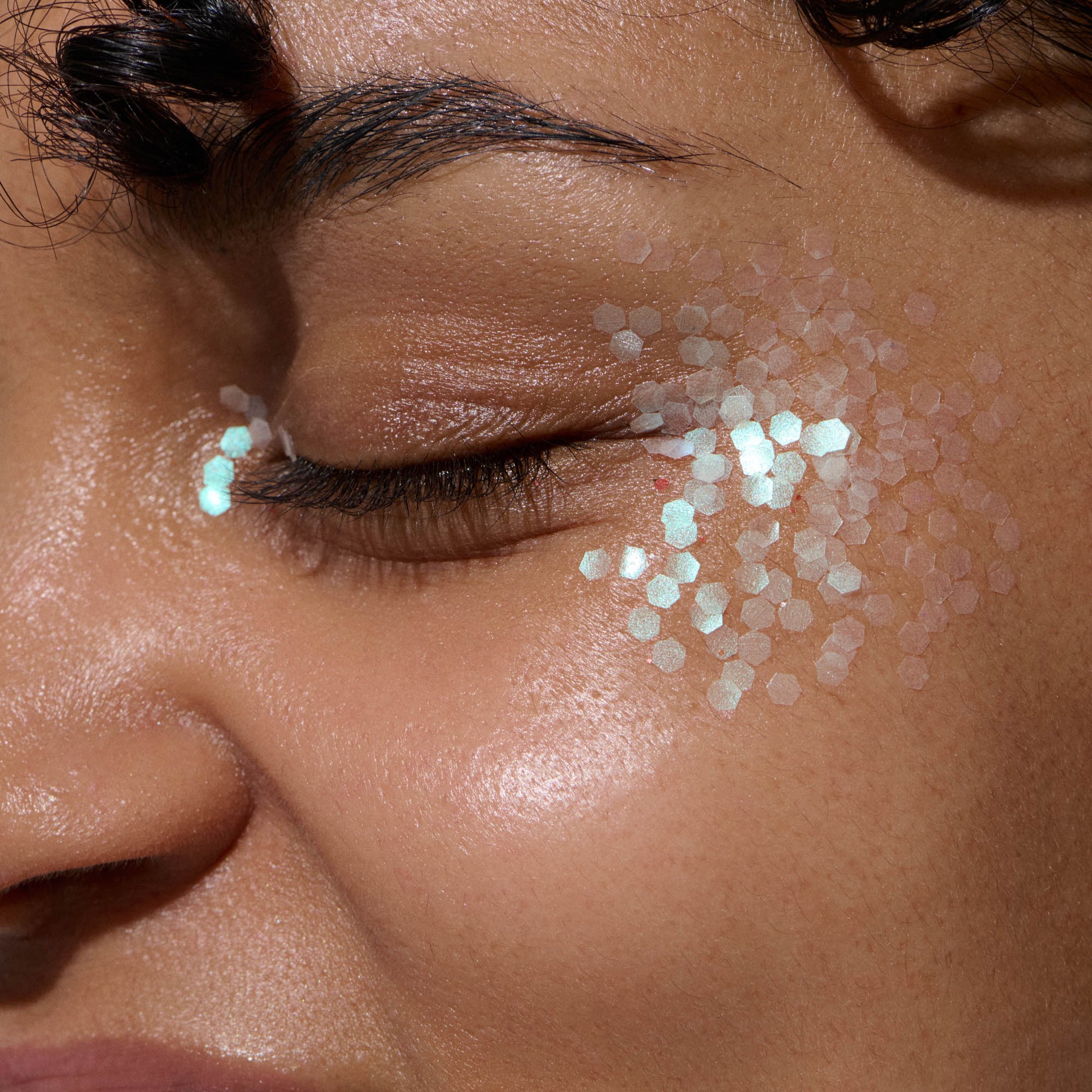 close up of woman with lucid green bioglitter on face